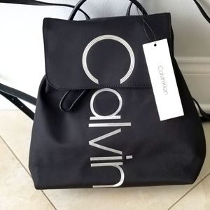 Calvin Klein ladies backpack NWT. Black fabric body & chrome letters.